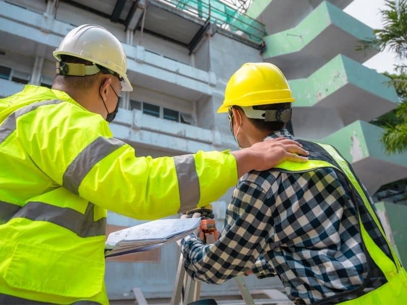 Construction professionals coordinating new residential development connected to existing roads and utility infrastructure