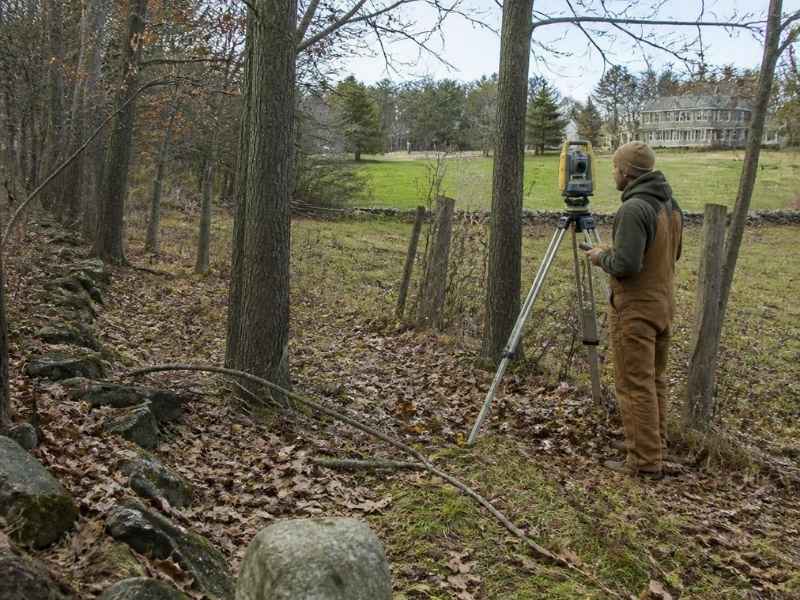 boundary surveyor researching historic property lines with old markers and fence evidence in bowling green kentucky
