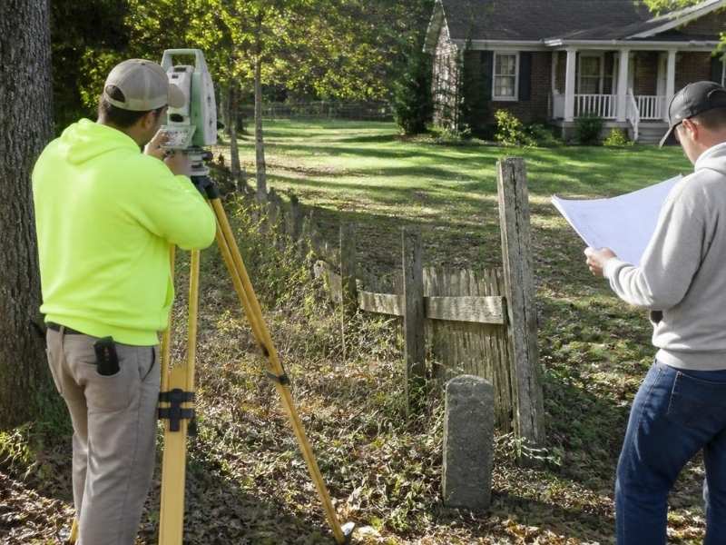 old deed boundary survey bowling green ky | Bowling Green Land Surveying Land surveyor comparing old property records with modern boundary measurements in Bowling Green, KY.